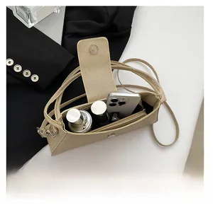 Detail of the champagne woven baguette bag interior showing capacity for cosmetics and phone