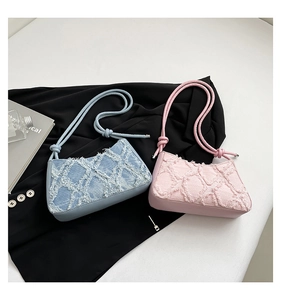 Dettaglio di borse a spalla in denim e rosa trapuntato con frange e tracolla con nodo