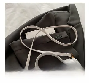 Macro shot of white crocodile texture PU leather hand bag with gold buckle hardware detail