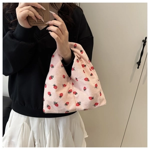 Détail du sac fourre-tout en velours côtelé rose avec imprimé fraise et texture côtelée