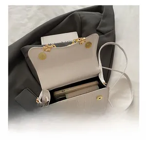 Internal view of a white croc-embossed box bag showing space for a phone and wallet