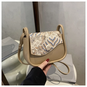 Detail of Chinese style shoulder bag showing wave pattern embroidery on the flap cover