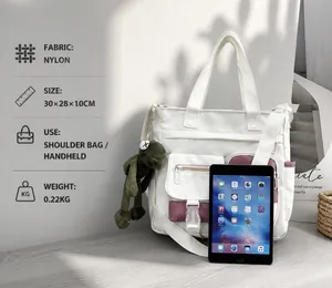 Dettaglio della borsa tote in nylon con ciondolo a rana verde e specifiche dimensionali