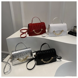 Detail of trendy croc-embossed mini box bags in four colors with gold chain handles