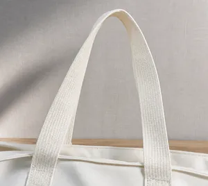 Dettaglio del manico in tela color crema con trama intrecciata fitta e cuciture precise