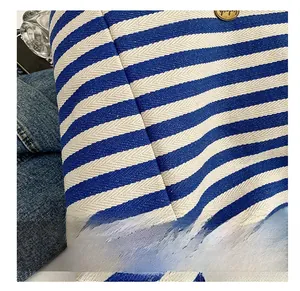 Vue détaillée du tissu en maille rayée bleu et blanc avec bouton métallique de style vintage