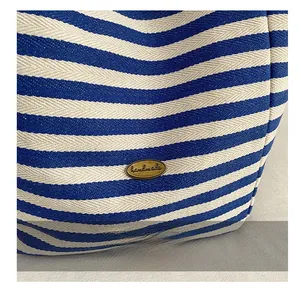 Gros plan sur le tissu tricoté à rayures bleues avec une étiquette métallique handmade