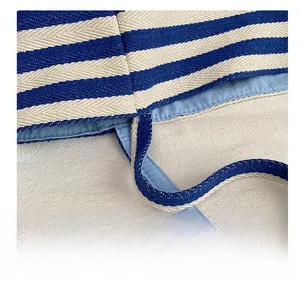 Vue macro des coutures précises du sac cabas en toile rayée bleue et blanche avec doublure