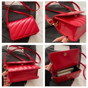Detailweergave van een rode gewatteerde crossbodytas met gouden metalen gespen