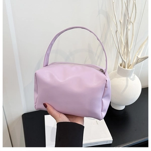 Close-up of a light purple PU leather handbag with a smooth metal zipper and top handle