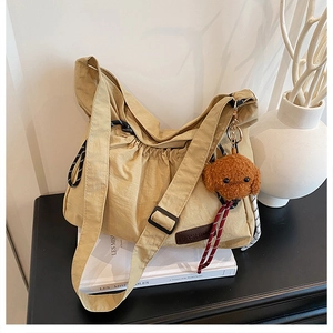 Detalle del bolso de nailon caqui con parche de moda y adorno de osito de peluche