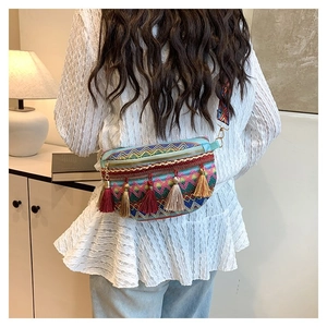 Detail of bohemian fringe waist bag with colorful geometric woven patterns and jacquard strap
