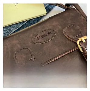 Close-up of vintage brown PU leather saddle bag with fashion logo and gold buckle details