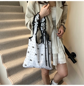 Detailansicht des Rüschen-Schultergurts und der schwarzen Schleife an einer Polka-Dot-Tasche