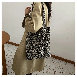 Dettaglio della borsa shopper in tela leopardata indossata con un trench beige elegante