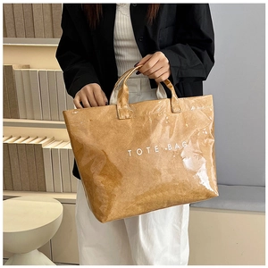 Détail d'un grand sac cabas en papier kraft avec revêtement PVC imperméable porté par un mannequin