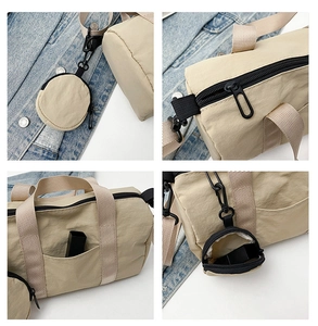 Detalle de bolso Boston beige con cremallera, bolsillo lateral y mini monedero colgante
