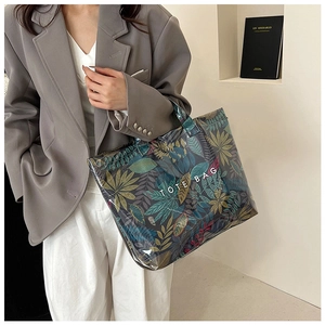 Close-up of a large tote bag with tropical leaf print and transparent PVC overlay