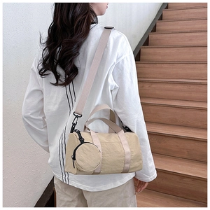 Detalle del bolso Boston beige con correa ajustable y pequeño monedero redondo
