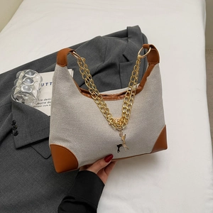 Elegante borsa tote con trama intrecciata bianco sporco, dettagli pelle e ciondolo