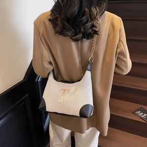 Elegante borsa tote in tela grigia con finiture in pelle e ciondolo a forma di cervo