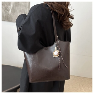 Große dunkelbraune Shopper-Tasche mit stylischem Baseball-Anhänger am Schulterriemen