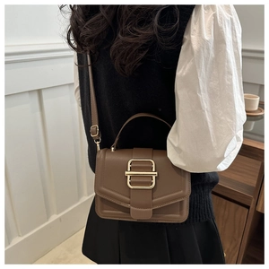 Sac bandoulière en cuir marron avec boucle dorée présenté en vue latérale arrière
