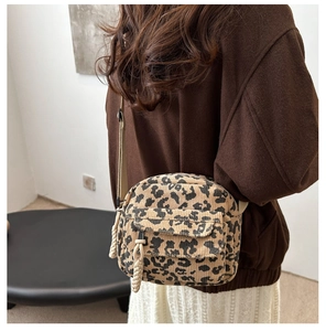 Détail du sac bandoulière en velours léopard avec cordon tressé sur une tenue décontractée