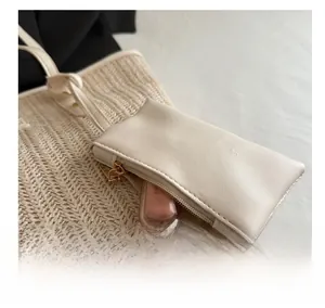 Detail of detachable beige PU leather mini pouch charm for lipstick on woven straw tote