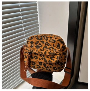 Détail du sac bandoulière en velours côtelé léopard avec poche avant et sangle réglable