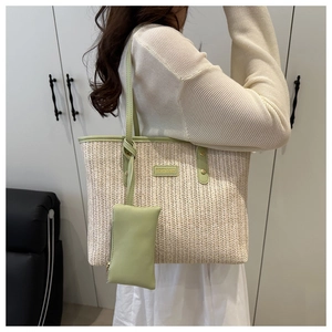 Close-up of woven straw tote bag with mint green leather trim and fashion brand tag
