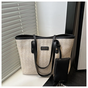 Macro detail of woven herringbone texture and black faux leather trim on a tote bag