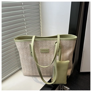 Detail of woven straw tote bag with green leather trim and matching small pouch