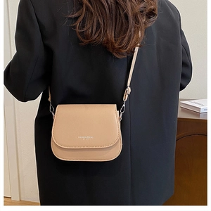 Sacoche selle beige avec texte Fashion Trend portée sur une veste de blazer noire