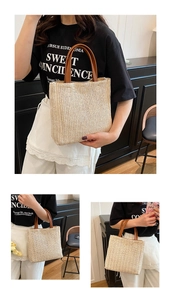 Détail du sac cabas en paille tressée avec anses en cuir contrastées et design seau épuré