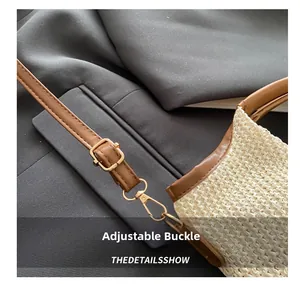 Détail de la boucle en métal doré réglable et de la bandoulière en cuir brun du sac