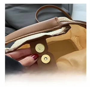 Vue macro détaillée de la boucle magnétique dorée sur un sac cabas en paille tressée