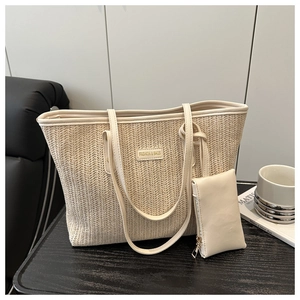 Detail of beige straw tote bag with wave texture, leather strap and mini pouch charm