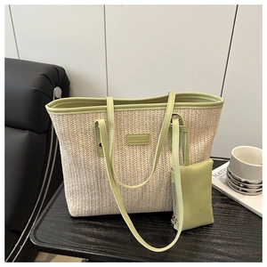 Detail of straw tote bag showing contrast leather trim and mini zipper pouch accessory