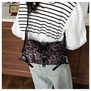 Rear view of a stylish leopard print shoulder bag worn with casual denim and striped shirt