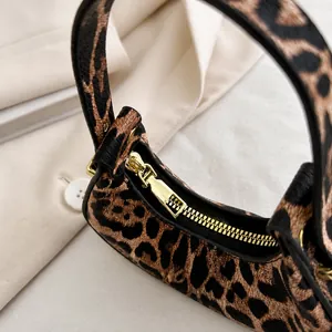 Nahaufnahme des glatten goldenen Reißverschlusses an der Baguette-Tasche mit Leopardenmuster