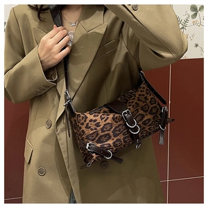 Détails d'un sac à main léopard avec boucles argentées et anses en cuir marron