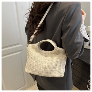 Détail du sac cabas tissé beige montrant la texture ondulée et les lanières en cuir fin