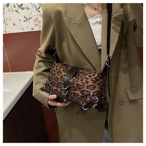 Detail of vintage leopard print tote bag with brown leather straps and silver rings
