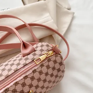 Dettaglio della cerniera dorata e della trama litchi sulla borsa Boston rosa