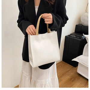 Vue détaillée d'un sac cabas blanc minimaliste avec une anse kaki et des coutures précises
