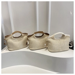 Détail de sacs cabas en paille avec poignées en cuir et anneaux en D métalliques