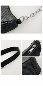 Detailweergave van de zwarte geweven handtas met zilveren ketting en ritsdetails