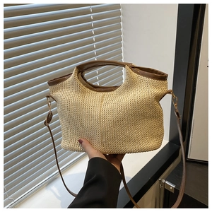 Vue détaillée de la texture en paille tressée et poignée en cuir d'un sac d'été chic