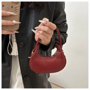 Dettaglio mini borsa a mezzaluna rossa con cerniera dorata e finitura in ecopelle liscia